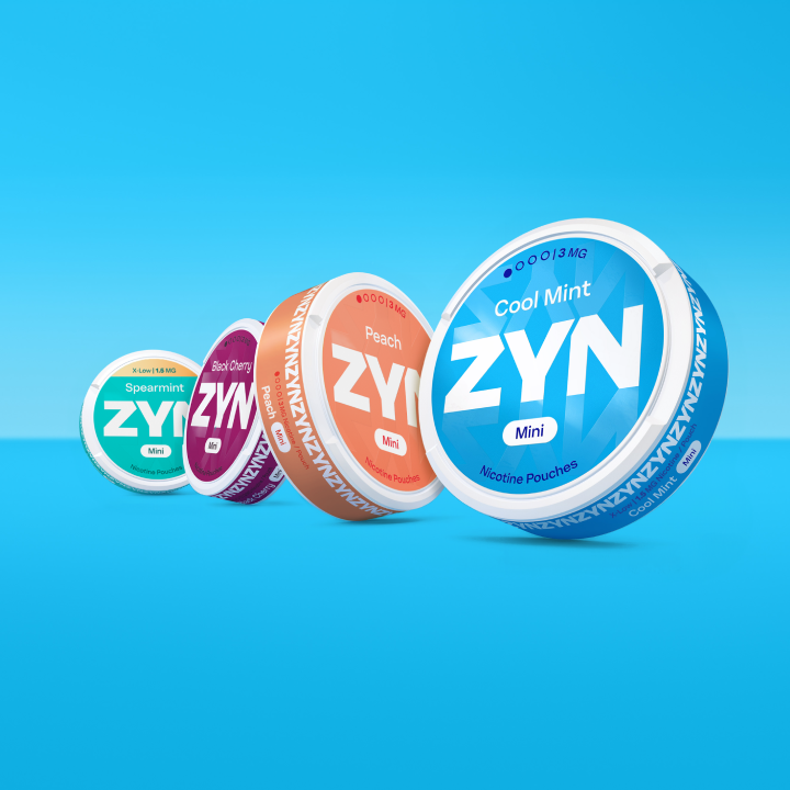 Quatre boîtes ZYN Mini fermées (Spearmint vert clair, Black Cherry rouge, Peach rose, Cool Mint bleu), sur fond bleu clair