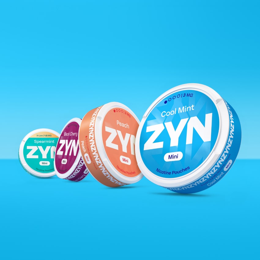 Four closed ZYN cans (light green Spearmint, red Black Cherry, pink peach,  blue Cool Mint) , on a light blue background