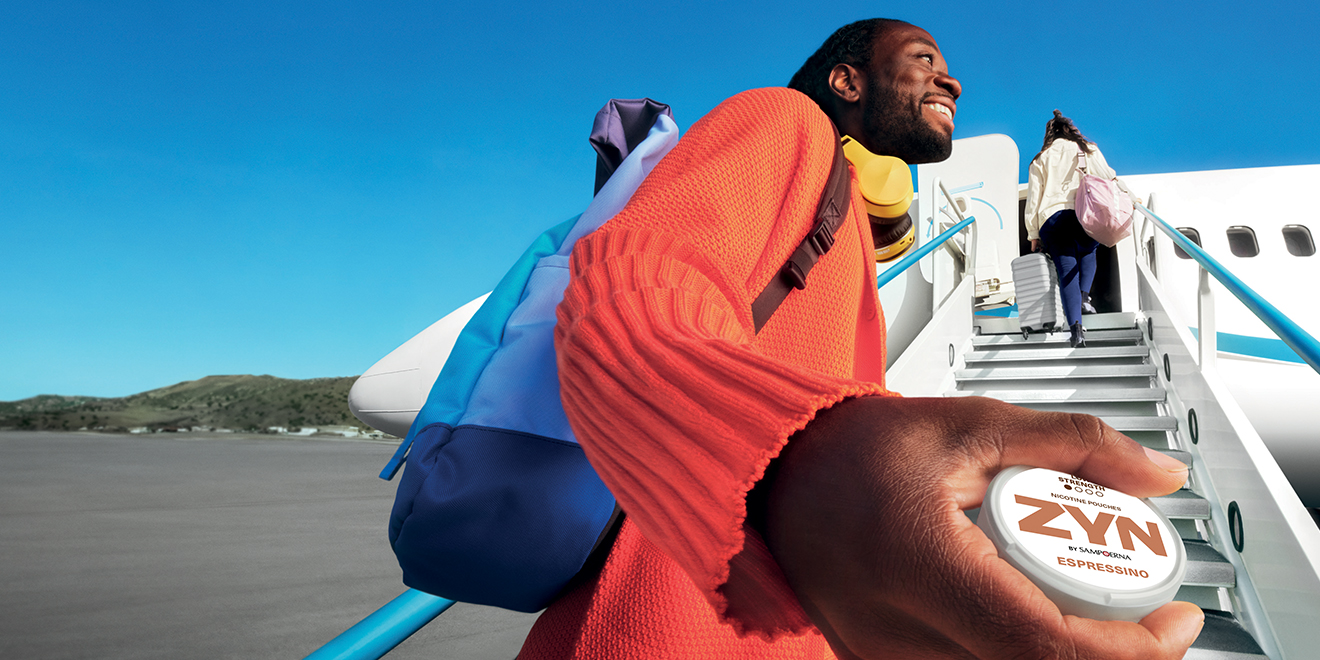 Men boarding a plan and holding ZYN. 