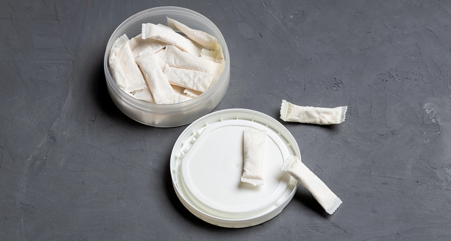 Person steckt eine ZYN-Dose in die Innentasche eines blauen Blazers.