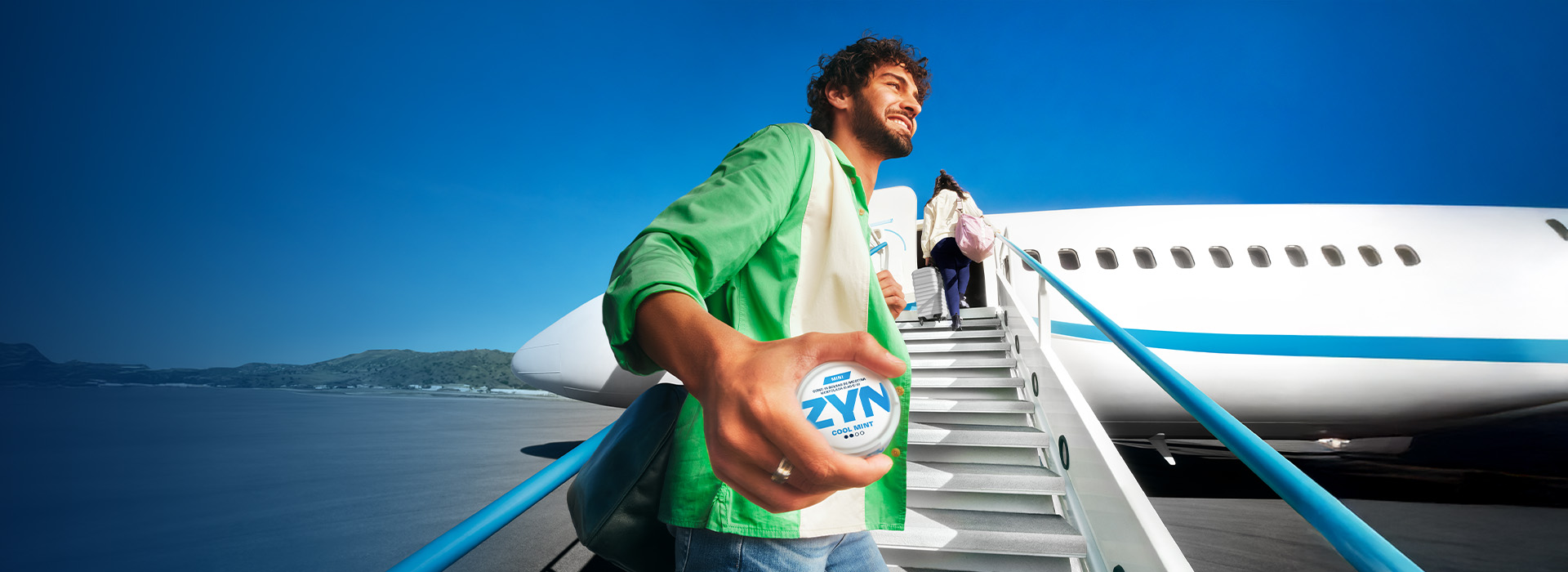 Hombre subiendo a un avion sosteniendo una lata de bolsas de nicotina Zyn