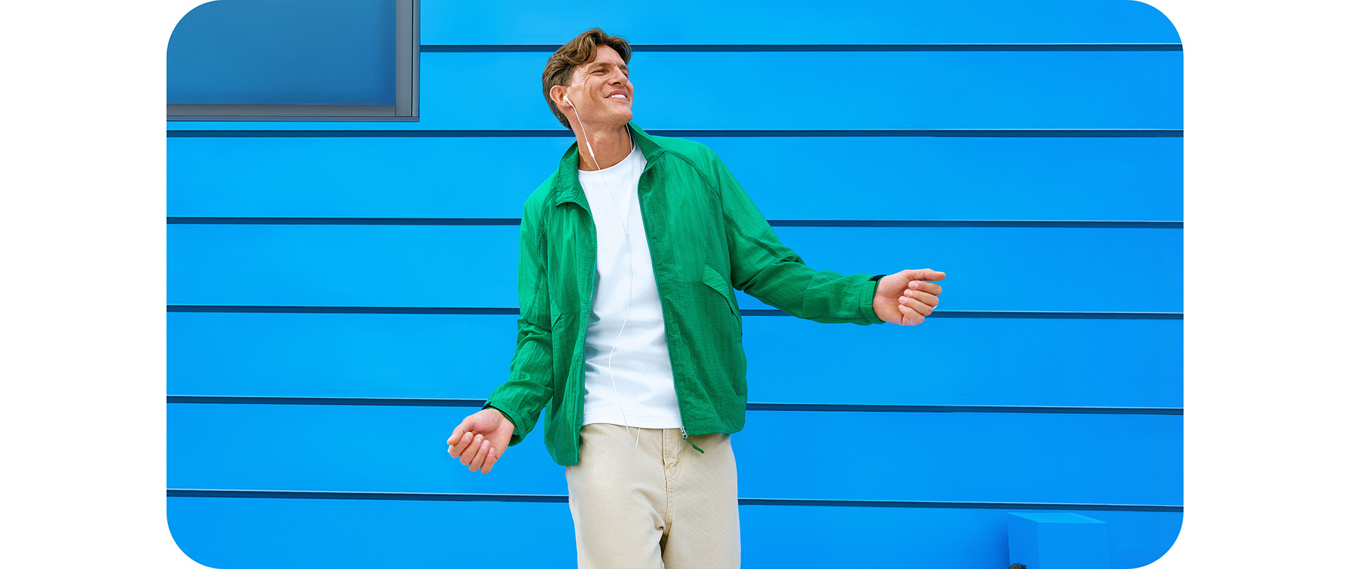 vidéo d'un homme portant une chemise blanche et un sweat vert, écoutant de la musique