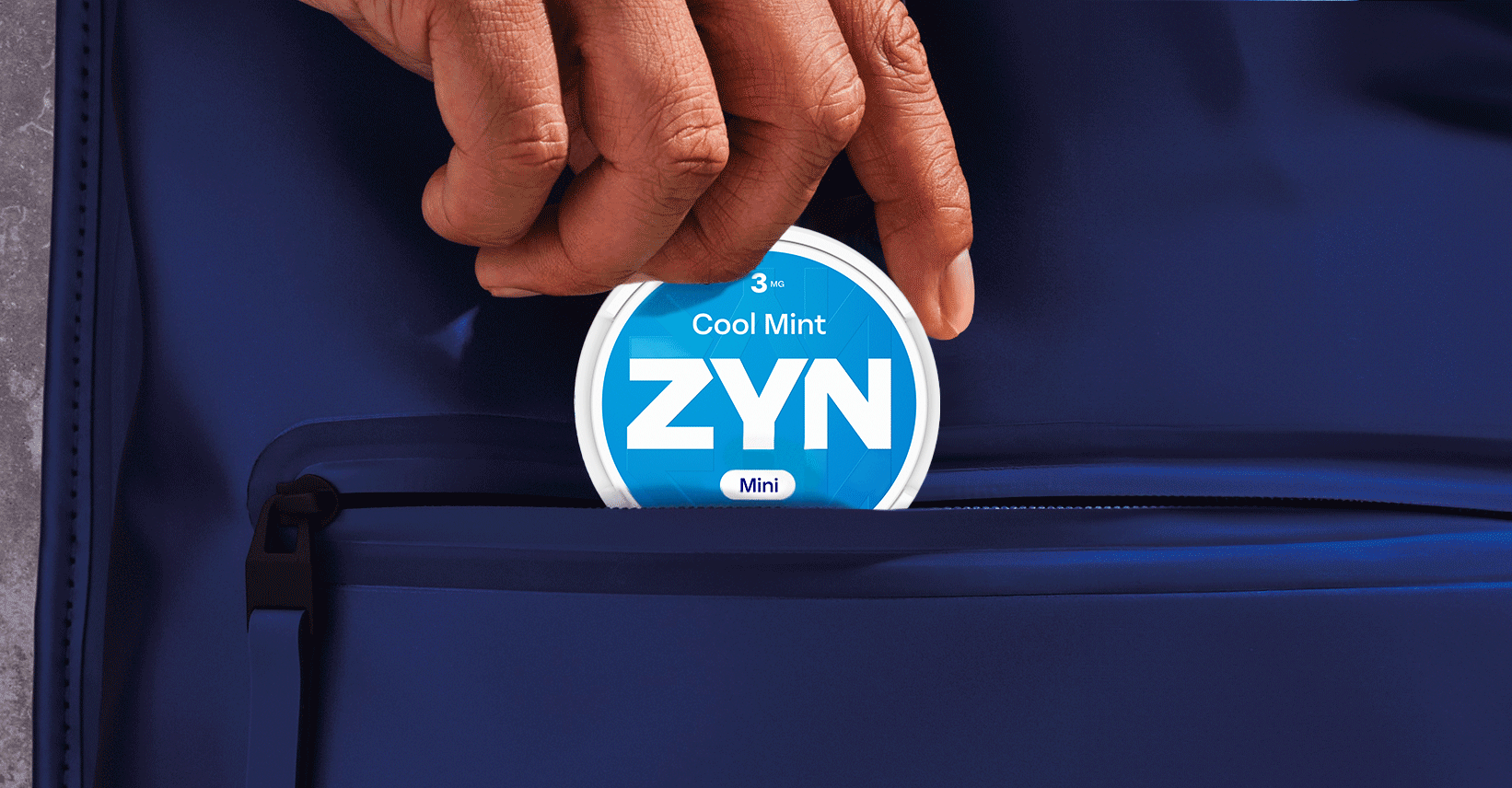 Boîte de ZYN Cool Mint bleue au-dessus d'une enceinte stéréo bleue.