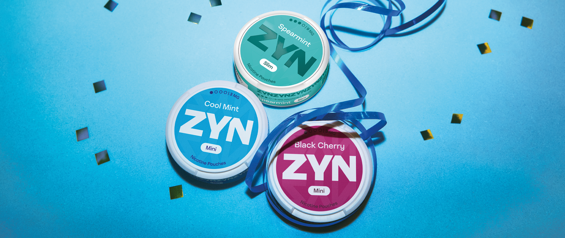 Blue ZYN Cool Mint can, red ZYN Black Cherry can and green ZYNSpearmint can on blue background