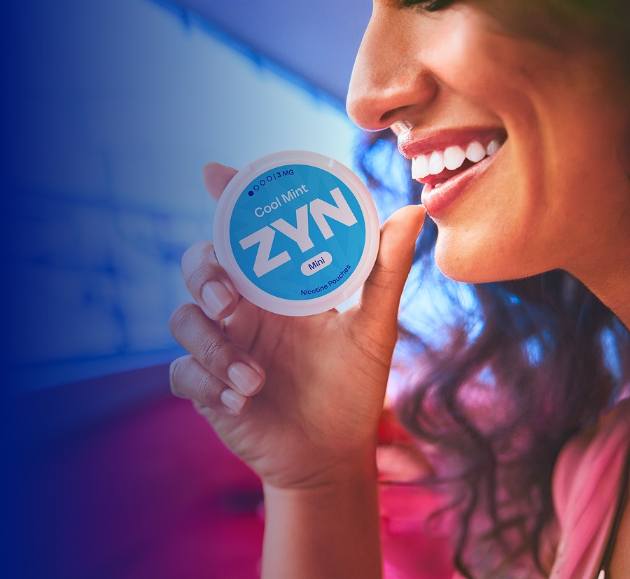 Mujer sonriendo mientras sostiene una lata de ZYN
