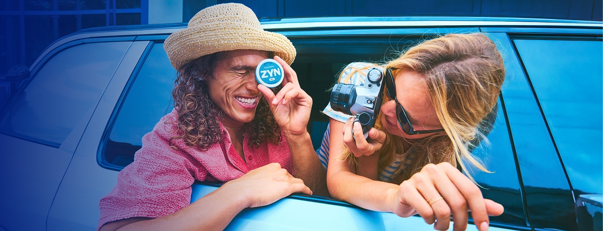 Dos chicos en auto sosteniendo una lata de ZYN