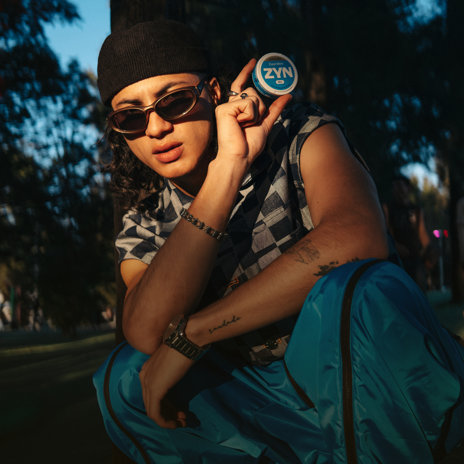 Persona en un entorno de festival al aire libre sosteniendo una lata de ZYN.