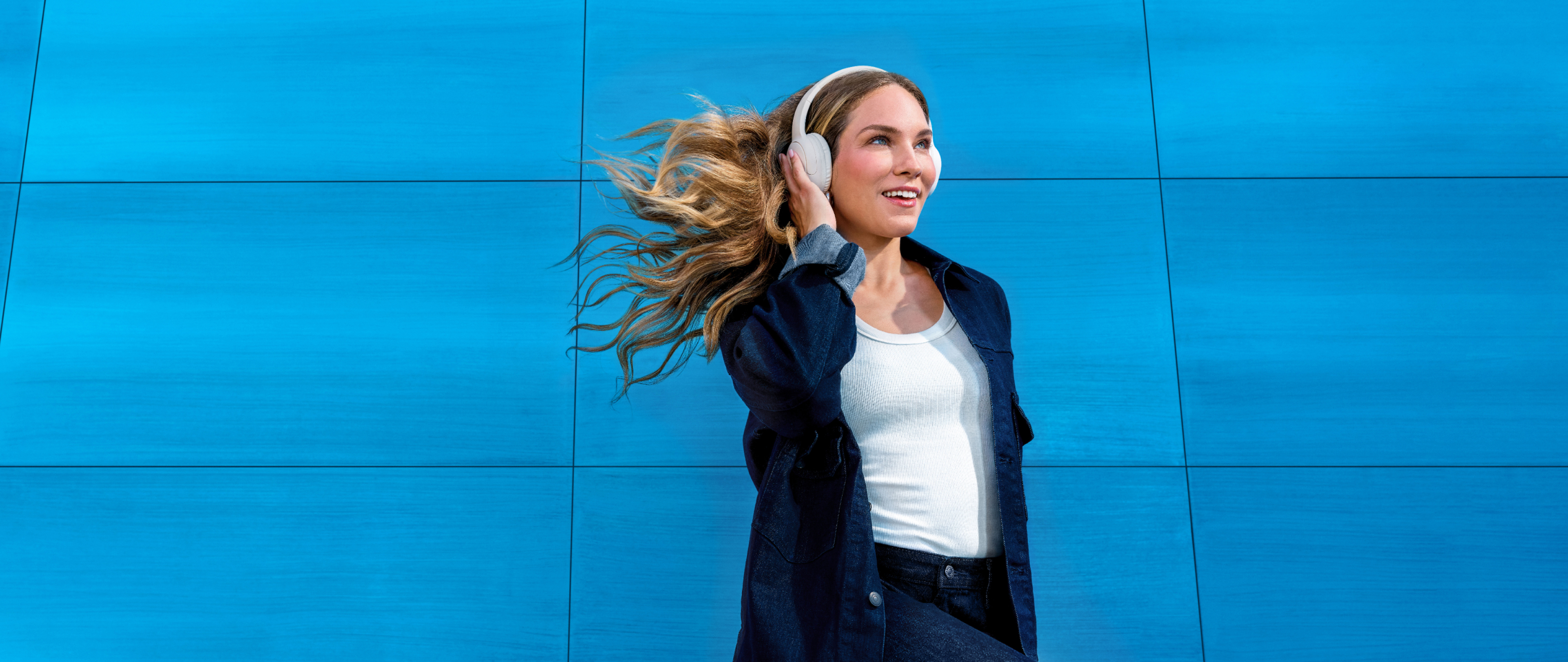 Mujer con cabello largo y rubio con auriculares escuchando música - ZYN