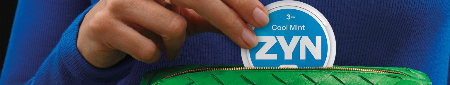 Mujer sacando de su cartera verde una lata de Zyn Cool Mint 1,5 mg