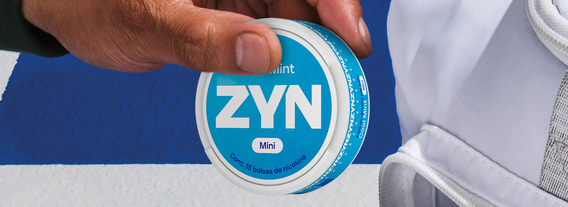 Mano con lata de bolsas de nicotina abierta 