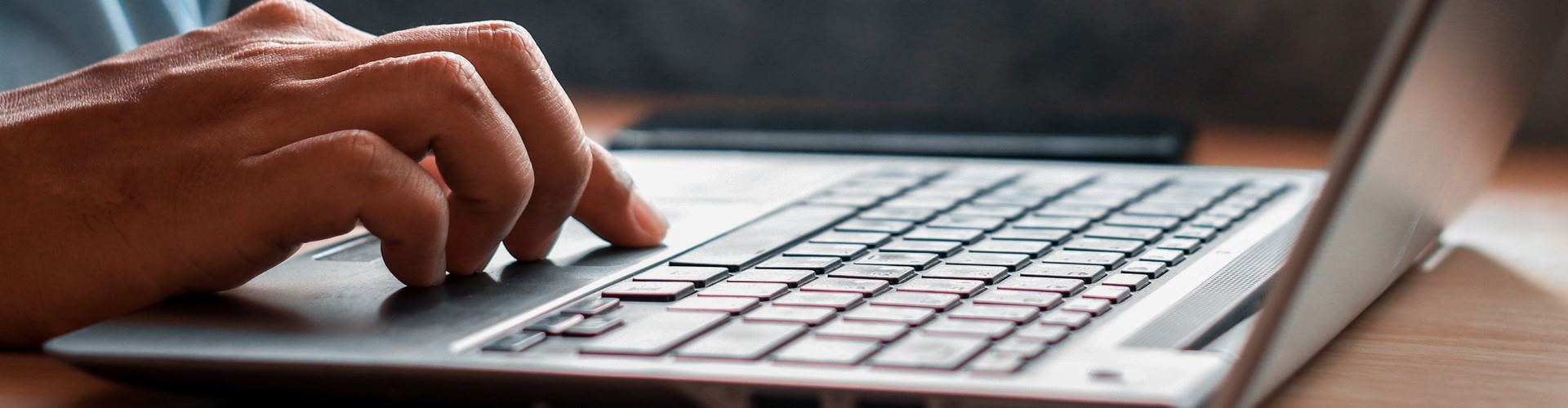 Zbliżenie na dłoń na klawiaturze laptopa