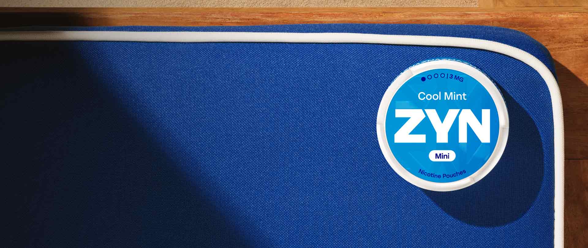 Opakowanie saszetek nikotynowych ZYN leżące na granatowym siedzisku