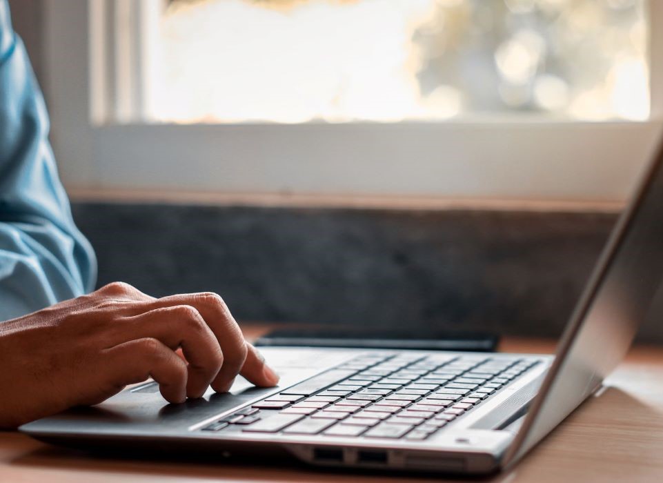Zbliżenie na dłoń na klawiaturze laptopa