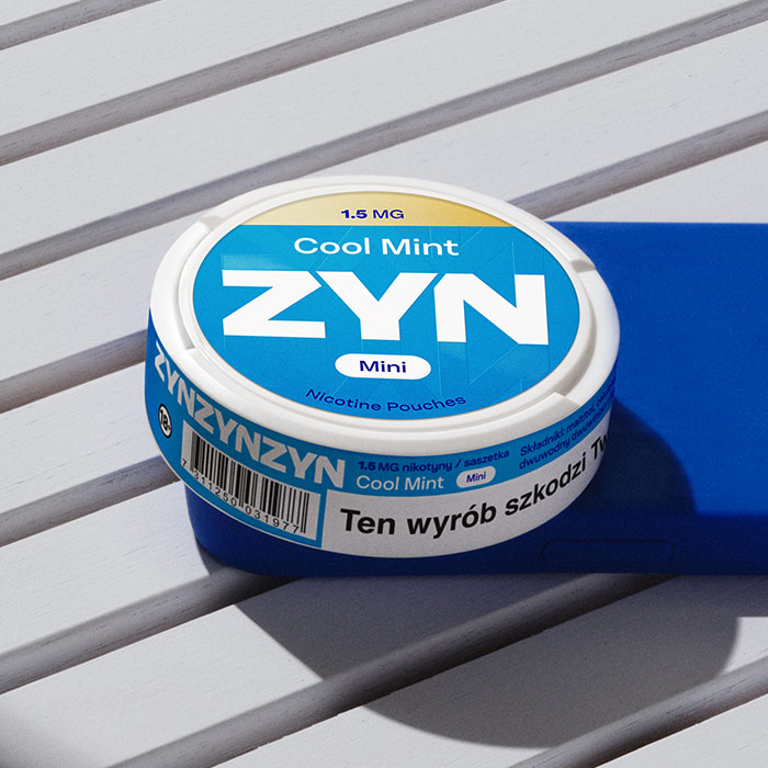 Puszka ZYN Coo mint leżąca na niebieskim smartphonie 