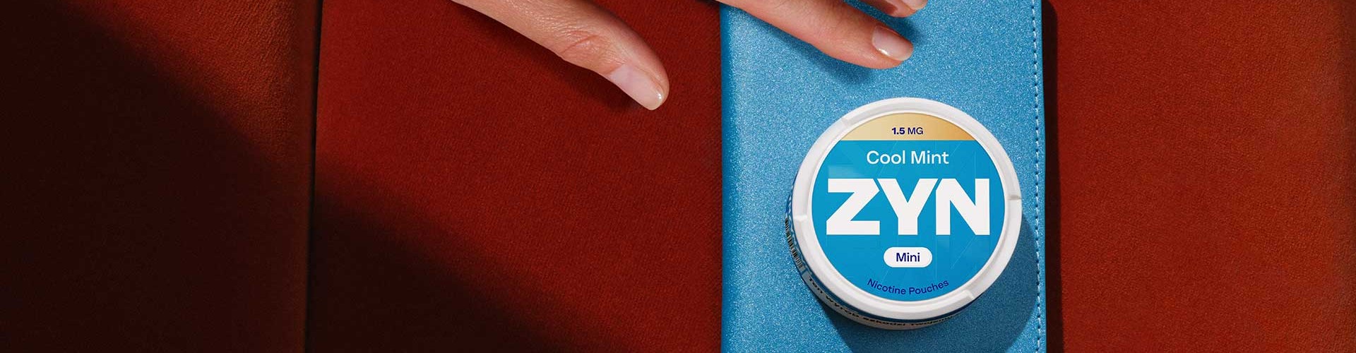 Opakowanie saszetek nikotynowych ZYN Cool Mint 1,5 mg leżące na niebieskim etui